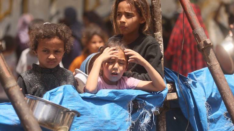 Niños de Gaza esperan con la esperanza de recibir alimentos.