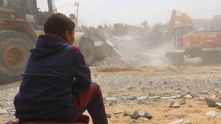 Un niño observa la recuperación de cadáveres bajo los escombros de una casa en el barrio de Al-Nasr, al este de la ciudad de Rafah, en el sur de la Franja de Gaza.