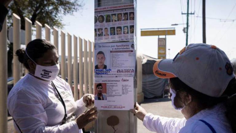 Madres buscadoras pegando carteles en calles de México.