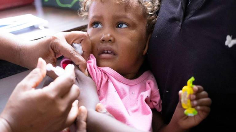 Una niña recibe una vacuna durante una campaña de inmunización en Venezuela.