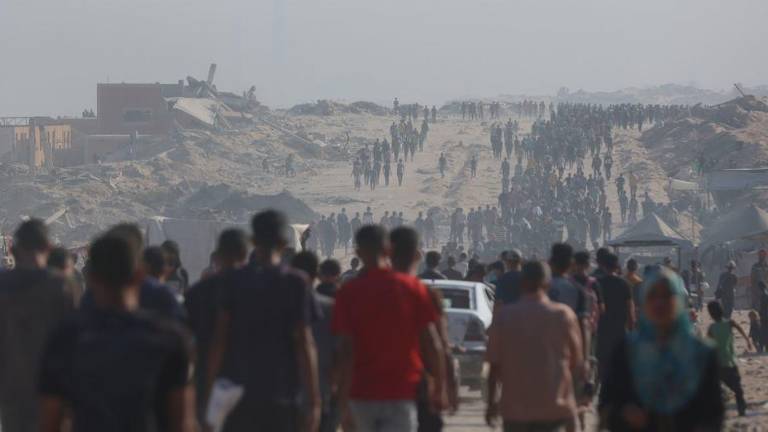 La gente camina hacia un punto de entrega de ayuda humanitaria en el norte de la Franja de Gaza.