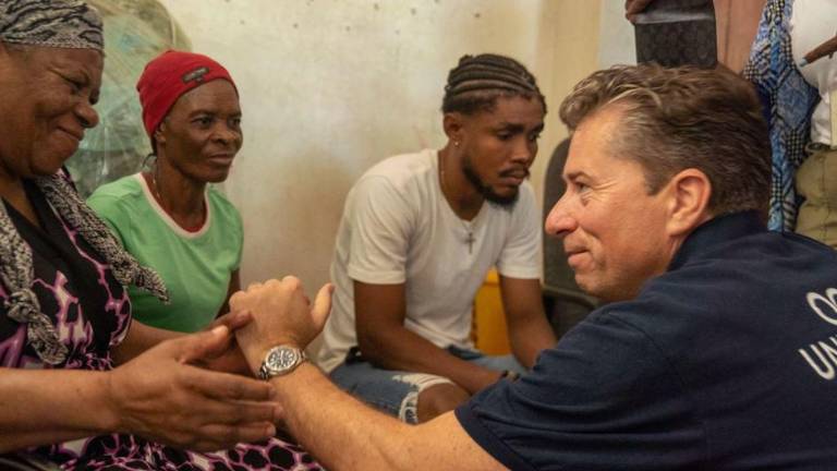 El coordinador de ayuda humanitaria de la ONU, Tom Fletcher, se reúne con una familia en Puerto Príncipe, Haití.