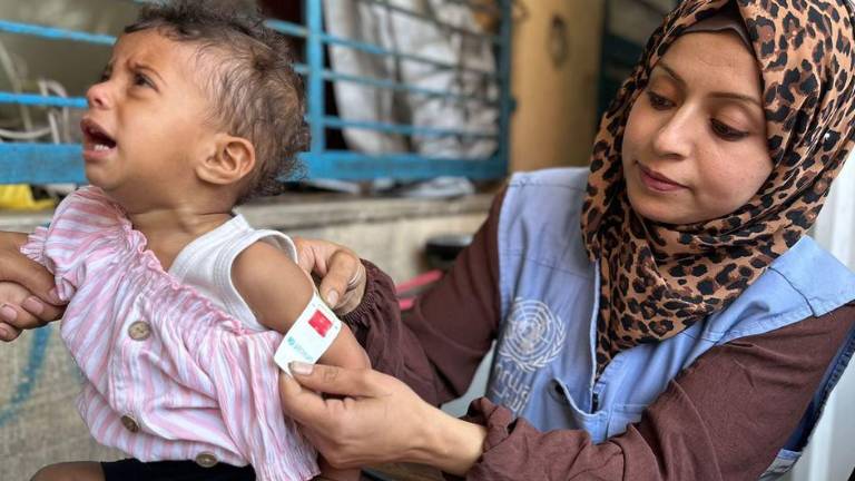 Una trabajadora de UNRWA en Gaza comprueba si un niño presenta signos de desnutrición.