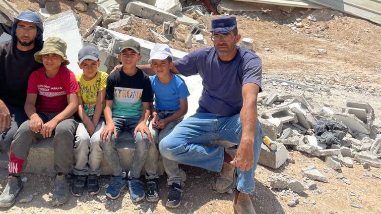 Habitantes de Massafer Yatta, en el sur de Cisjordania, sentados frente a edificios demolidos.