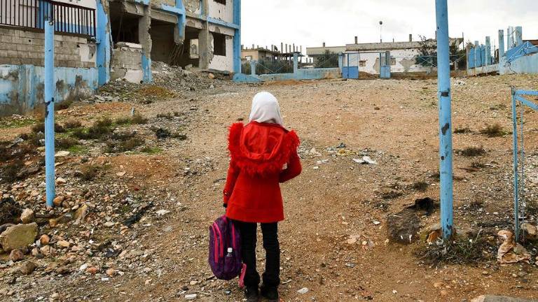 Una niña camina por una escuela destruida en Daraa Albalad, en el sur de Siria.